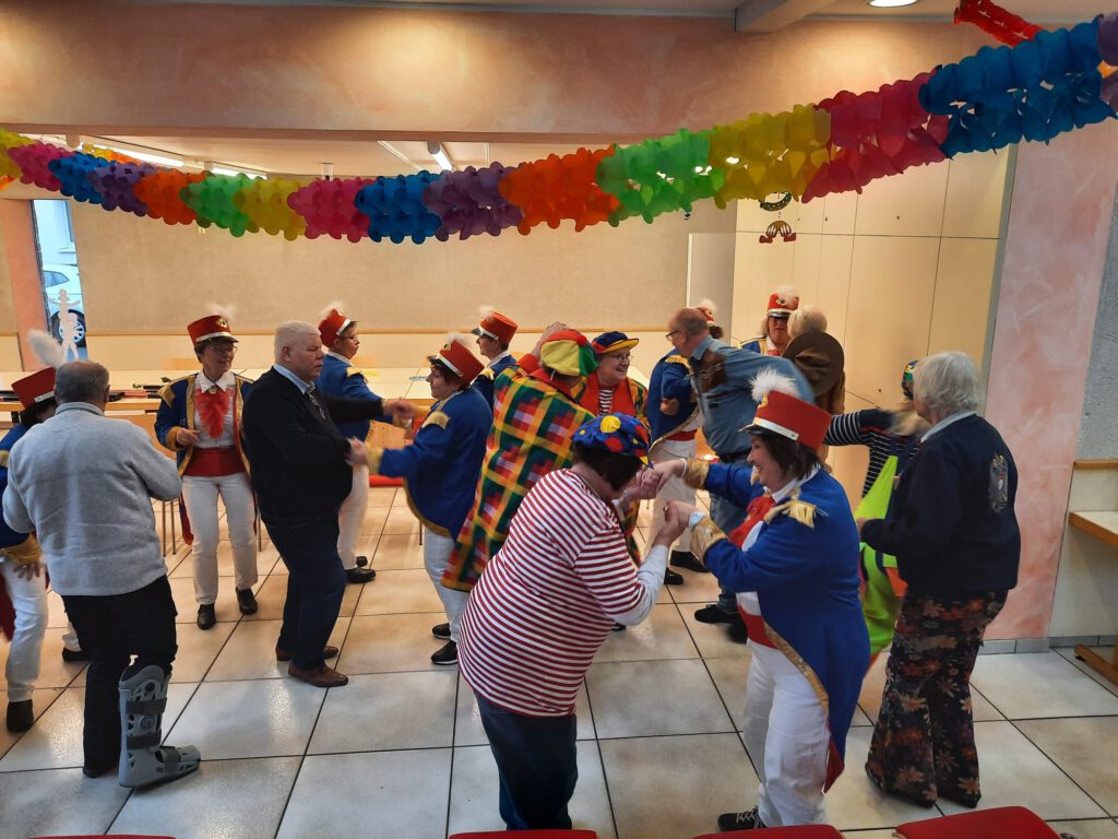 Kostümierte Menschen tanzen und feiern Karneval.